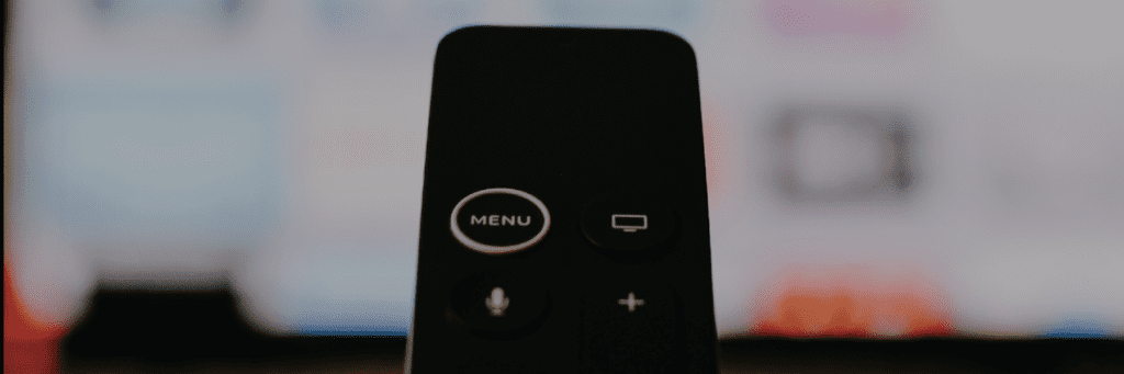 Photo of a hand on a remote scrolling through tv settings