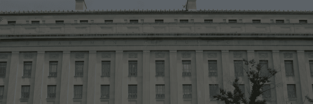 Exterior of the U.S. Department of Justice building with columns and the “Department of Justice” inscription across the façade